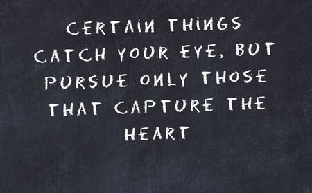 Black chalkboard with handwritten wise motivational quote .の写真素材