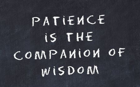 Black chalkboard with handwritten wise motivational quote .の写真素材