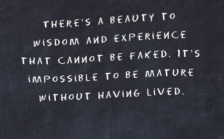 Black chalkboard with handwritten wise motivational quote .の写真素材