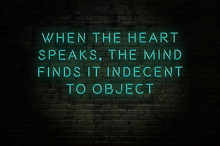 Wise quotation as light neon sign on brick wallの写真素材