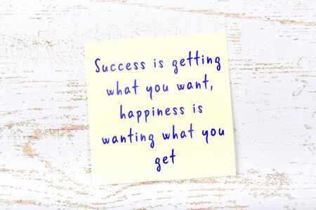Wise quotation handwritten on yellow sticky note hanging on wooden wallの写真素材
