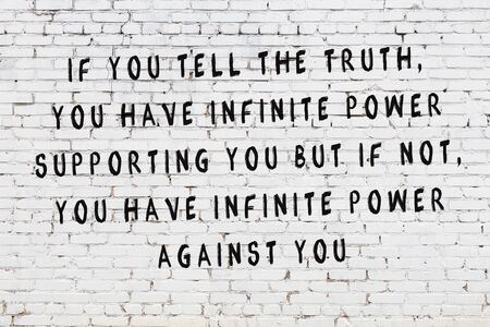White brick wall and  black painted inscription of  wise quotationの写真素材