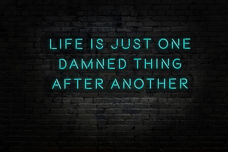 Night view on neon inscription of wise quotation on brick wallの写真素材