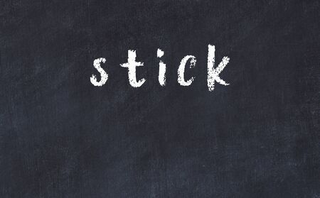 Chalk handwritten inscription stick on black deskの写真素材