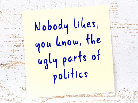 Yellow sticky note with handwritten motivational quotation on wooden wallの写真素材