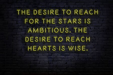 Wise quotation as light neon sign on brick wallの写真素材