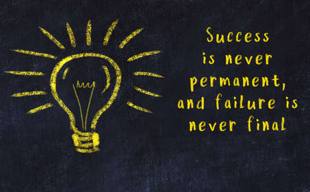 Smart quotation handwritten on a chalkboard and a light bulb sketchの写真素材