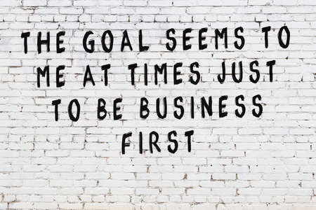 Black painted inscription of smart quotation on white brick wallの写真素材