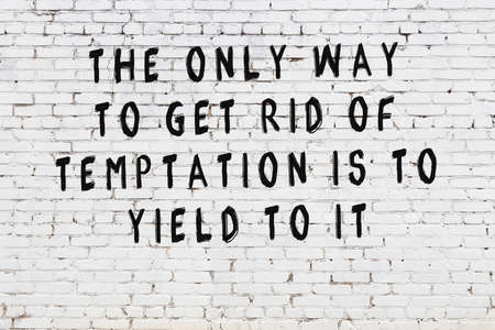 White brick wall and  black painted inscription of  wise quotationの写真素材