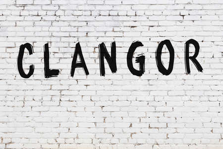 White brick wall with inscription clangor handwritten with black paintの写真素材