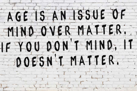 Black painted inscription of smart quotation on white brick wallの写真素材