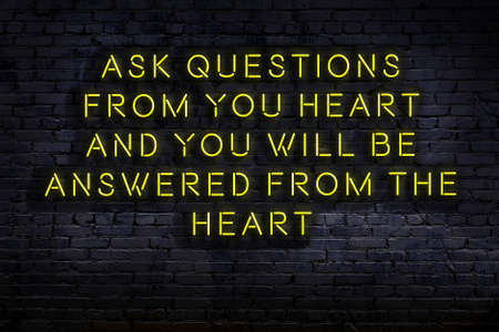 Wise quotation as light neon sign on brick wallの写真素材