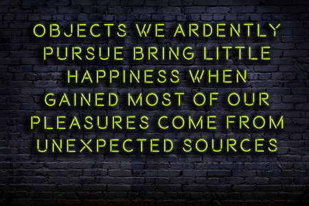 Wise quotation as light neon sign on brick wallの写真素材