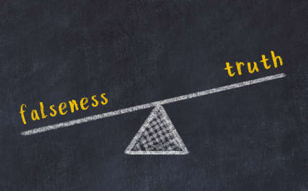 Chalk drawing of scales with words falseness and truth on black board. Concept of balanceの写真素材