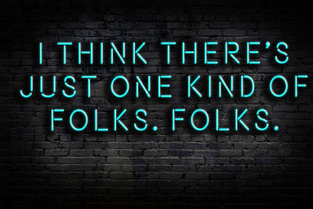 Wise quotation as light neon sign on brick wallの写真素材