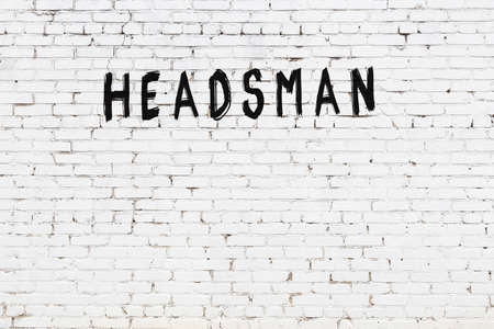 Inscription headsman written with black paint on white brick wall.の写真素材