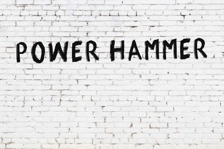 Inscription power hammer written with black paint on white brick wall.の写真素材