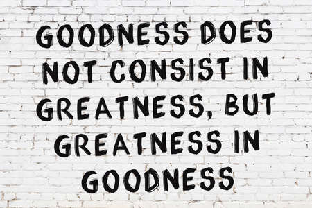 Black painted inscription of smart quotation on white brick wallの写真素材