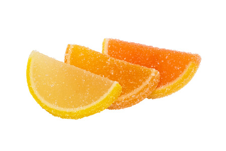 Three slices of yellow and orange marmalade sprinkled with sugar, lying one on another, and are located on a white background.の写真素材