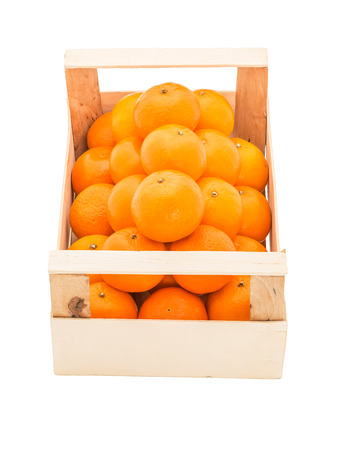 Ripe, juicy tangerines in a wooden box stacked as pyramid, on a white backgroundの写真素材