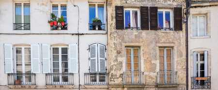 Facades of old buildings with windows, shutters and a small balcony in a provincial European townの写真素材