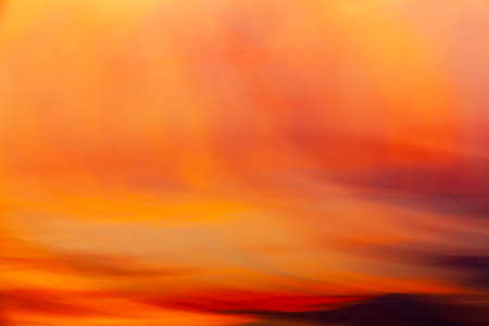 Pastel red-yellow sunset clouds shooted with long shutter speed and wave camera motion. Abstract backgroundの写真素材