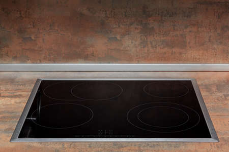 A freshly cleaned glass surface of an electric cooker built into the kitchen worktop. Close-up view with copy spaceの写真素材