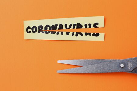 The word "Coronavirus", cut in half with scissors. The concept of defeating the epidemic and pandemic and successful vaccinationの写真素材