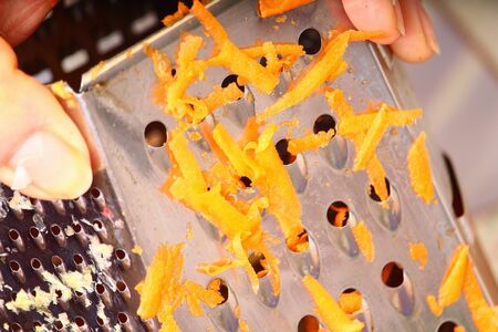 The process of rubbing carrots on a grater in cooking homemade food