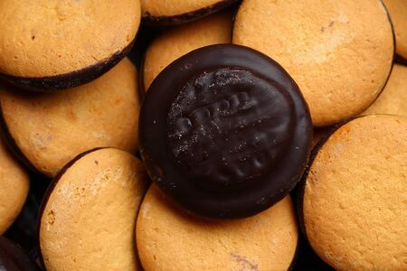 Chocolate glazed factory cookies close-up, background Conceptual and symbolic background.の写真素材