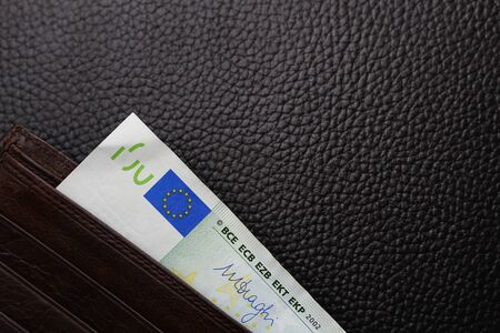 Euro in a brown wallet close-up on a black leather background