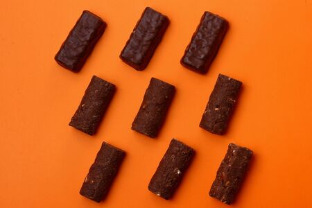 Chocolate candies on an orange background, dessertの写真素材