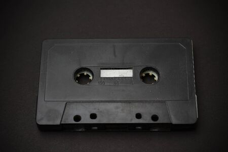 Black audio cassette close-up on a black backgroundの写真素材