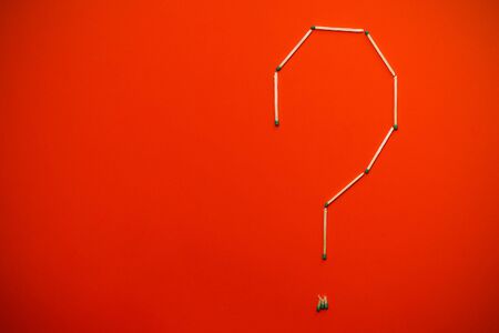 Question mark made of matches on an orange background with vignetting effect, abstract background with place for text or inscriptionの写真素材