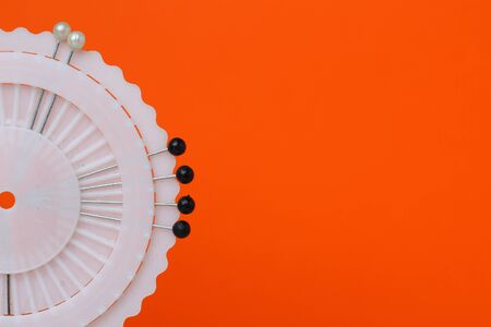 Needles in a round case on an orange background with place for text.の写真素材
