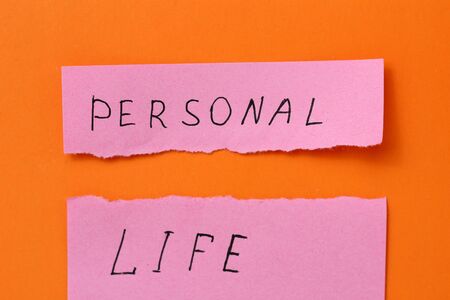 The inscription on the sticker: PERSONAL LIFE torn in half on an orange background
