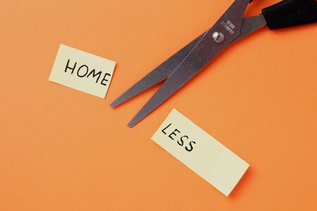 The inscription on the sticker: HOMELESS cut in half on an orange backgroundの写真素材