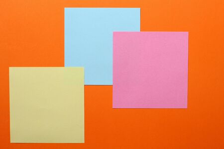 Multicolored stickers on an orange background with copyspace for inscription or text.の写真素材
