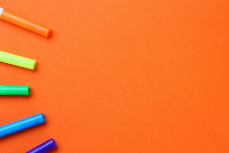 Multi-colored felt-tip pens on an orange backgroundの写真素材