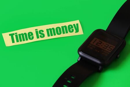 Sticker with the inscription or text: Time is money on a green background with a smart watchの写真素材