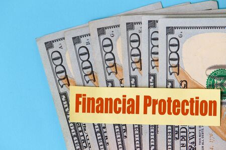 Sticker with the inscription or text: Financial protection on the background of dollarsの写真素材