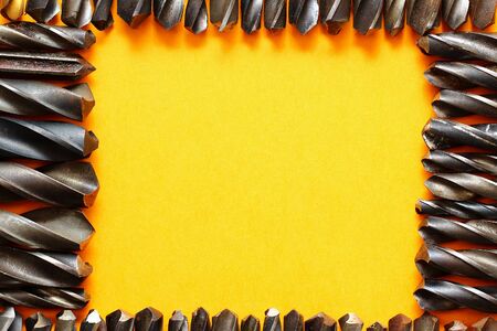 Many drills form a frame for placing an inscription or text on a trendy yellow background.の写真素材