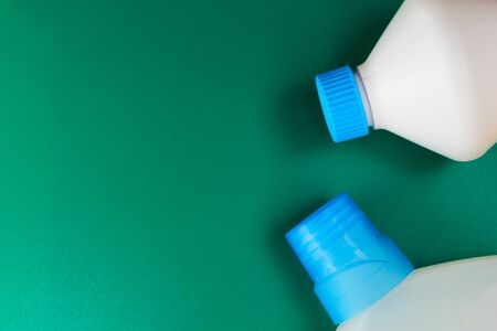 Chlorine-based disinfectant bottle caps on a green background with place for an inscription or textの写真素材