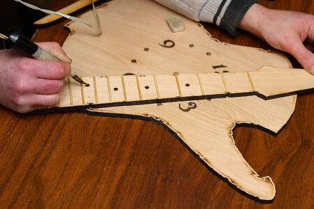 The process of burning on a texture tree with a special device. Unusual hobby. Toned backgroundの写真素材