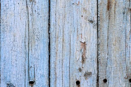 Old textured wooden fence with peeling paint backgroundの写真素材