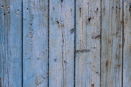Old textured wooden fence with peeling paint backgroundの写真素材