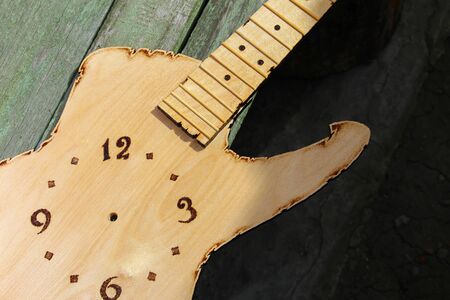 Abstraction of a clock on an artificial guitar, toned backgroundの写真素材