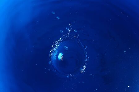 Abstract toned blue background with splashes of water, wallpaper blank, substrate for text or lettering, pattern for designの写真素材