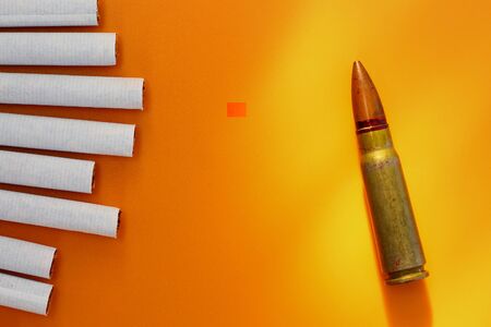 Cigarettes and bullet, metaphor for killing the body with nicotine addiction
