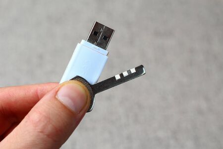 Key and flash drive in hand, symbol of trade secret